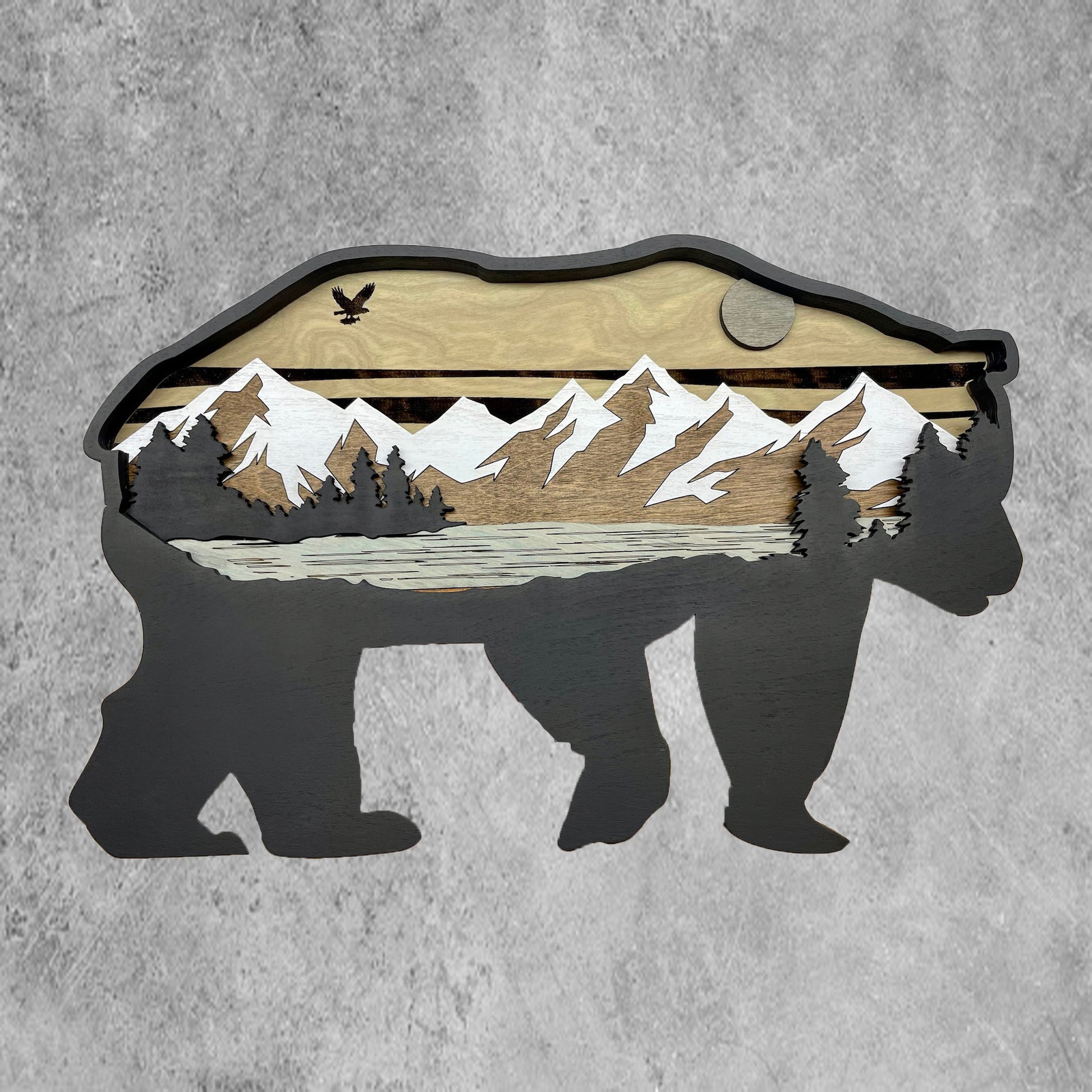 Enhance your walls with intricate Grizzly Bear artwork featuring 3D, outdoor-inspired elements. Details such as eagle and cloud engravings add substantial depth, and finished with a coat of black acrylic paint.